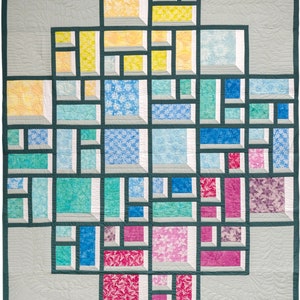 Puede incluir: Una colcha con un diseño geométrico que presenta una variedad de colores y patrones. La colcha está compuesta por cuadrados y rectángulos, con cada sección teniendo un patrón diferente. Los colores incluyen amarillo, azul, verde, rosa y blanco.