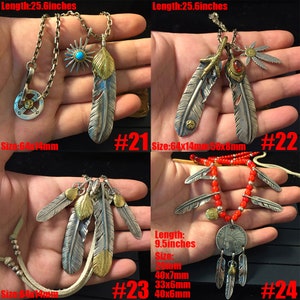 May include: Four silver and gold feather necklaces with different designs. The necklaces are 25.6 inches long and feature a variety of feather shapes and sizes. The necklaces are numbered 21, 22, 23, and 24.