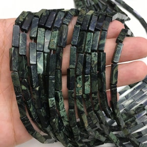 May include: A strand of dark green and black gemstone beads, each bead is a rectangular prism with a polished finish.