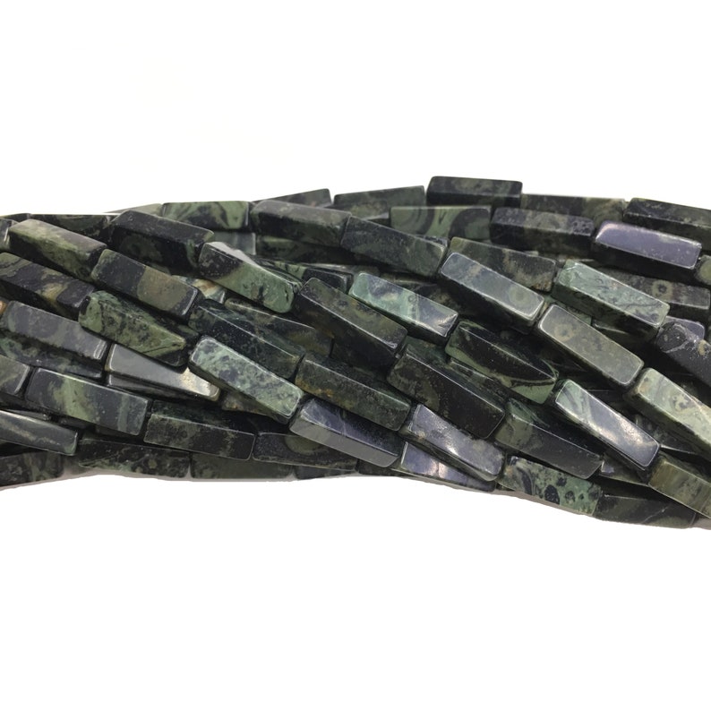 May include: A strand of dark green and black gemstone beads, each bead is a rectangular prism with a marbled pattern.