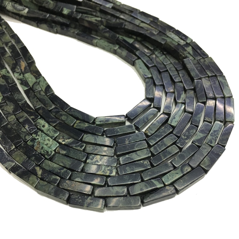 May include: A strand of dark green and black gemstone beads, each bead is a rectangular prism with a marbled pattern.