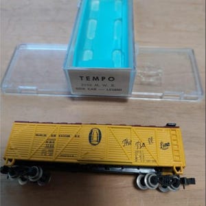 以下が含まれることがあります： 黒い車輪と「The Ba Line」の文字が入った黄色のTempoボックスカーモデル。 モデルは、ターコイズの内装の透明なプラスチックケースに入っています。 ボックスカーには黒と青のマーキングがあります。