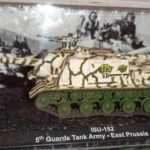 Op de afbeelding: Een model van een ISU-152 tank met een camouflagepatroon van bruin en groen. De tank heeft groene rupsbanden en het nummer 175 aan de zijkant. De basis leest "ISU-152 5th Guards Tank Army - East Prussia - 1945".