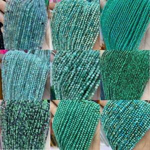 Puede incluir: Una colección de hilos de pequeñas cuentas facetadas en varios tonos de verde y azul. Las cuentas parecen ser piedras preciosas, con colores que van desde el turquesa claro hasta el esmeralda oscuro. La imagen es un primer plano, que muestra la textura y las variaciones de color.