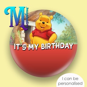 May include: A circular button with a cartoon image of Winnie the Pooh in a red shirt. The button has the text "IT'S MY BIRTHDAY" and "I can be personalised" on a red and white background.