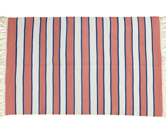 Könnte beinhalten: Rechteckiger Teppich mit vertikalen Streifen in Koralle, Weiß und Marineblau. Der Teppich hat Fransen an den Kanten. Die Streifen sind gleichmäßig angeordnet und erzeugen ein klares Design. Geeignet für den Innen- und Außenbereich. Maße in Zentimetern.