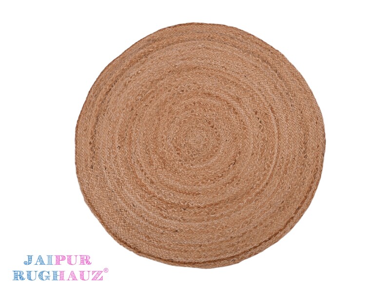 May include: A round, natural fiber rug with a woven texture. The rug is a light brown color and has a circular pattern.