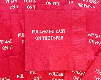 May include: A stack of red paper napkins with the text "FULLER! GO EASY ON THE PEPSI!" printed in white on the top napkin.
