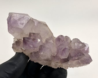 May include: A cluster of amethyst crystals with a deep purple hue. The crystals are arranged in a natural formation, showcasing their unique shapes and facets.