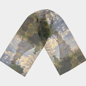 Puede incluir: Una bufanda de seda con una pintura de dos personas caminando por un campo con un cielo nublado. La pintura está en una paleta de colores suaves de azules, verdes y amarillos.