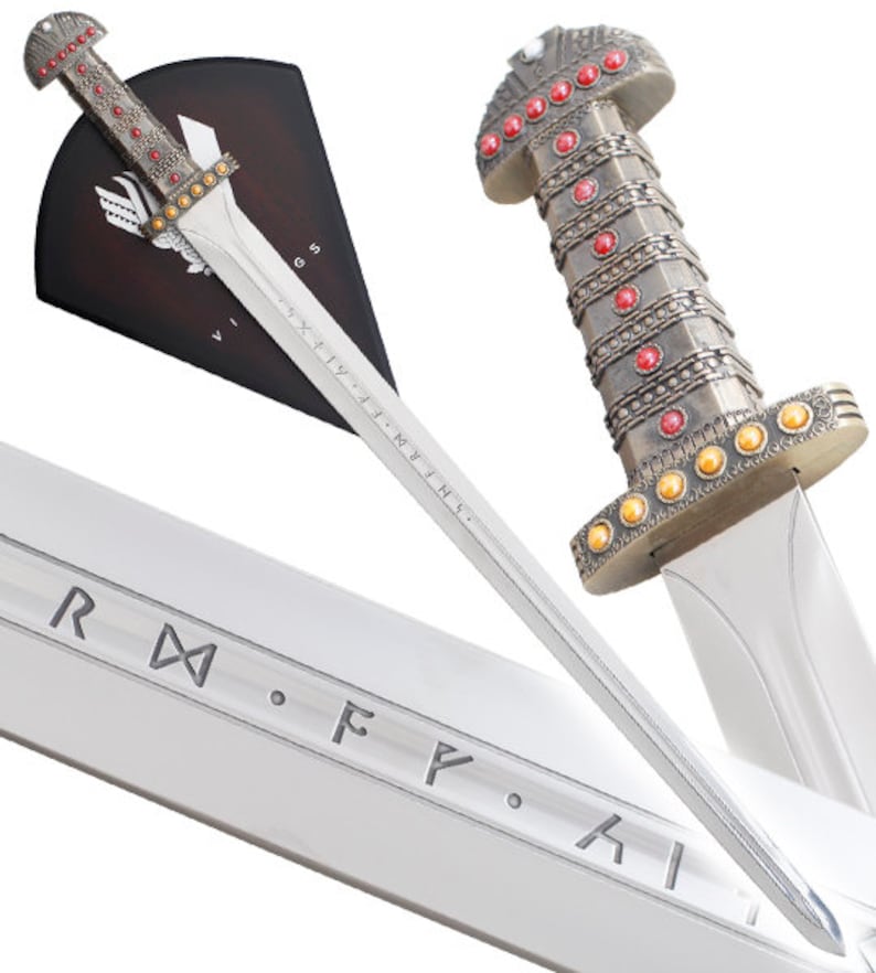 May include: A silver Viking sword with a wooden handle and a red and gold pommel. The sword is displayed on a wooden plaque with the inscription "IX.XI.MM.I.N.I." The sword is a replica of a historical Viking sword.