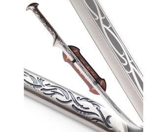 May include: A silver sword with a decorative handle and a silver scabbard with a decorative design. The sword is displayed on a stand.