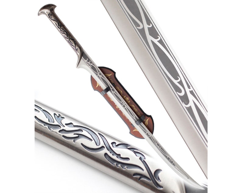 May include: A silver sword with a decorative handle and a silver scabbard with a decorative design. The sword is displayed on a stand.