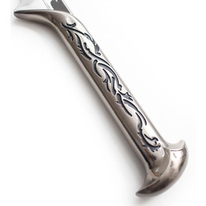 May include: Close-up of a silver sword hilt with a black floral design.