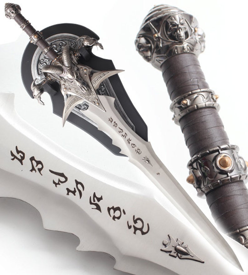 May include: A detailed fantasy sword with a silver blade and intricate handle design. The handle is wrapped in brown leather and features skull and metal accents. The blade has etched inscriptions and a decorative hilt.