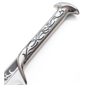 May include: A silver sword with a black and silver handle. The handle has an intricate design of swirling vines.