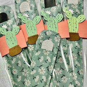May include: Five green nail files with a white floral pattern and a cactus design. Each file is packaged in a clear plastic sleeve.
