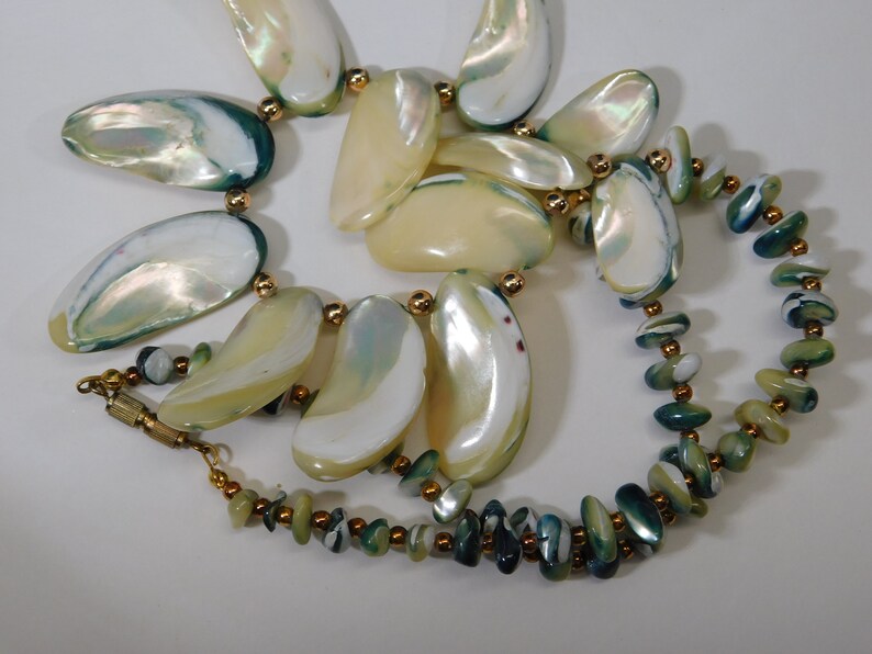 Shell necklace with blue green edges gold spacer beads and barrel clasp