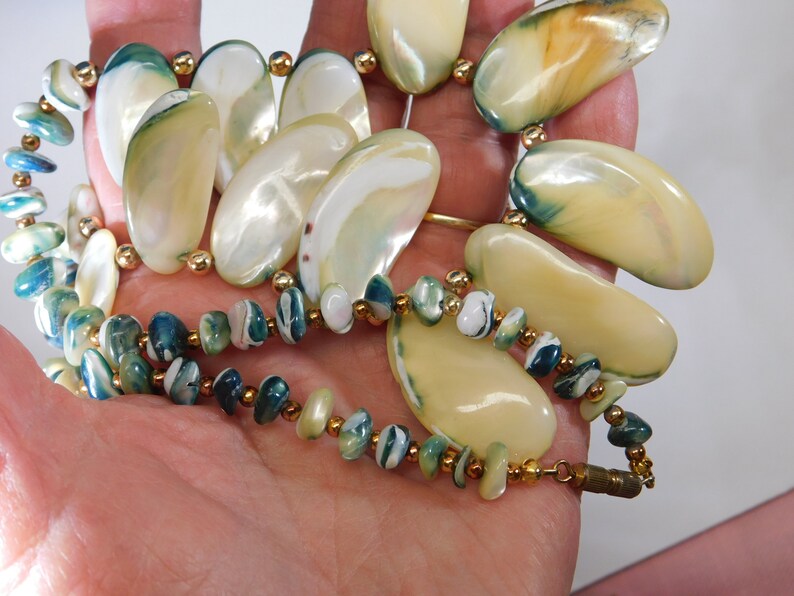 Shell necklace with blue green edges gold spacer beads and barrel clasp