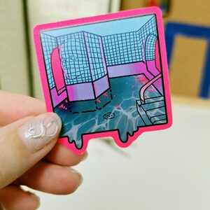May include: A square sticker with a bright pink border featuring a digital illustration of a tiled indoor pool area. The scene includes blue water, a ladder, and a grid-patterned wall with a faint, translucent face outline in shades of blue and purple.