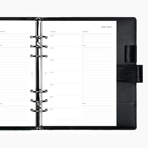 May include: A black leather ring binder planner open to a weekly layout page dated JAN 2027. The white paper features sections for priorities, to-do lists, and daily entries. A silver six-ring metal mechanism secures the pages in place.