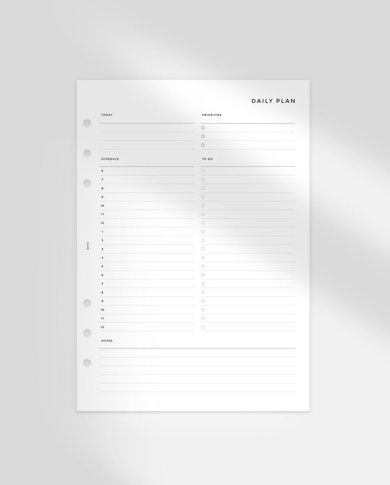 May include: A white daily planner with a black header that says "DAILY PLAN". The planner has sections for "TODAY", "SCHEDULE", "PRIORITIES", "TO DO", and "NOTES".