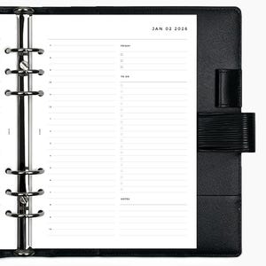 May include: Black leather planner open to a dated page for January 2, 2026. The page includes sections for the day's schedule, to-do list, and notes. The planner has a silver binder mechanism and a black strap closure.