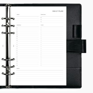 May include: A black leather bound daily planner with a silver ring binder. The planner has sections for "Today", "Priorities", "Schedule", "To Do", and "Notes".
