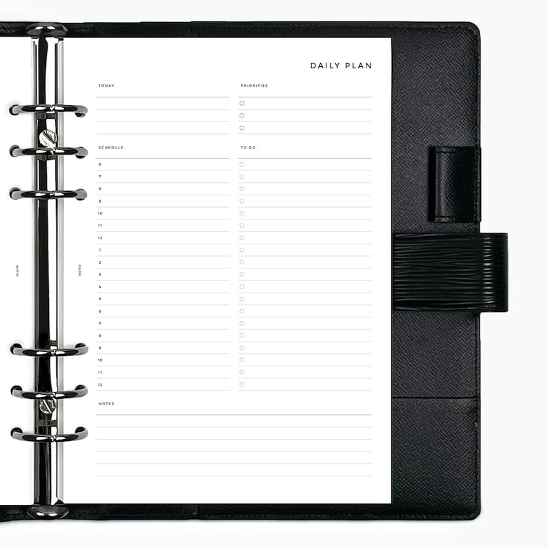 May include: A black leather bound daily planner with a silver ring binder. The planner has sections for "Today", "Priorities", "Schedule", "To Do", and "Notes".