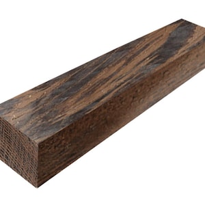 May include: A rectangular block of wood with a rich, dark brown color and striking black grain patterns. The wood appears to be freshly cut, with visible end grain texture. This piece could be used for woodworking projects or as a decorative element.