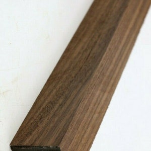 Peut inclure: Gros plan sur un cheville en bois brun foncé avec une section transversale carrée. Le bois présente un grain naturel et est lisse au toucher.