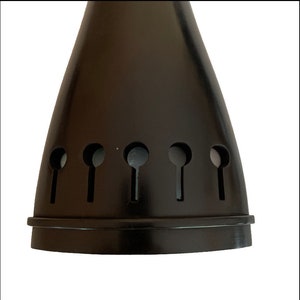 May include: Black metal lampshade with a cone shape and six cut-out holes. The holes are in a row and are shaped like a keyhole.
