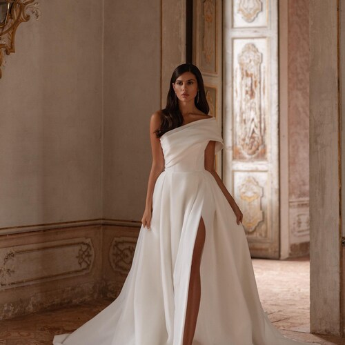 asymmetrical bridal dresses Asymmetric neckline wedding dress in salon WONA Unveil your inner goddess with this sophisticated asymmetrical wedding gown White Bridal Wedding Gowns 2026
