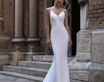 satin figure hugging wedding dress Sleek sophistication defines Sabrina, a stunning fit-and-flare gown crafted from luxurious Twill Mikado. Featuring a structured strapless neckline with chic fold-over detail, the silhouette gracefully hugs the body. A row of covered
