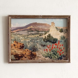 May include: A framed painting depicting a desert landscape with a rocky outcrop and red wildflowers in the foreground. The background features a distant mountain range under a blue sky.