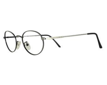Puede incluir: Gafas redondas con montura negra y varillas plateadas. Las lentes son transparentes y las almohadillas nasales son visibles. Las varillas tienen un diseño decorativo cerca de las bisagras. Las gafas están diseñadas para la corrección de la visión.