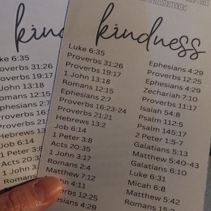 May include: Two white cards with the word "kindness" written in black cursive at the top. Each card lists a variety of Bible verses related to kindness, including Luke 6:35, Proverbs 31:26, Proverbs 19:17, 1 John 13:18, Romans 12:15, Ephesians 2:7, Proverbs 16:23-24, Proverbs 21:21, Hebrews 13:2, Job 6:14, 1 Peter 3:8, Acts 20:35, 1 John 3:17, Romans 2:4, Matthew 7:12, John 4:11, Proverbs 12:25, Ephesians 4:29, Zechariah 7:10, Proverbs 11:17, Isaiah 54:8, Psalm 112:5, Psalm 145:17, 2 Peter 1:5-7, Galatians 5:13, Matthew 5:40-43, Galatians 6:10, Luke 6:31, Micah 6:8, Matthew 5:42, and Romans 15:2.