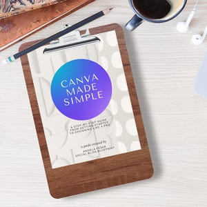 May include: A wooden clipboard with the text "CANVA MADE SIMPLE" is the focal point of this image. A smartphone, laptop, coffee cup, and headphones are also visible. The image has a clean, organized aesthetic, suggesting a workspace or study environment.