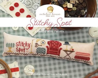 May include: A cross-stitch pattern with the text "Stitchy Spot" and miniature embroidered furniture. The image includes red buttons, a bowl of buttons, and the text "Skinny Mini Pattern" and "October House Fiber Arts".