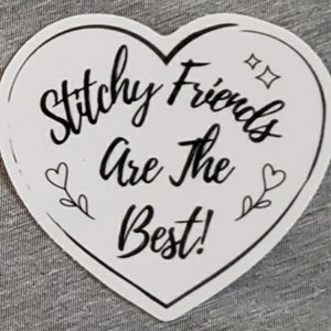May include: White heart-shaped sticker with black text that reads "Stitch Friends Are The Best!" with two small hearts and vines on either side of the text.