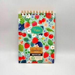 May include: A spiral-bound notepad with a vibrant fruit and floral pattern. The design features red strawberries and cherries, green leaves, and white flowers on a light teal background. The word "Notes" is in a teal bubble. The notepad is labeled "Recycled".