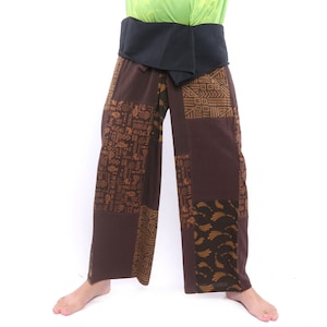 Op de afbeelding: Bruine broek met een zwarte band en een geometrisch patroon in goud. De broek is gemaakt van een zachte, comfortabele stof en heeft een losse pasvorm.