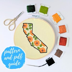 May include: A close-up of an embroidery hoop featuring a design of the state of California with orange poppies. The hoop is surrounded by spools of embroidery floss in various colours, including green, orange, brown, and black. The text "pattern and pdf guide" is written on a blue circle.