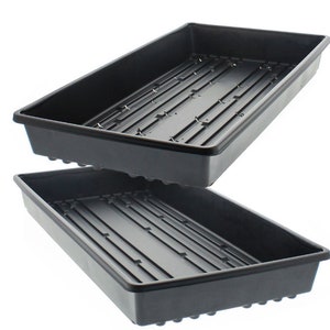 Pode incluir: Duas bandejas de semeadura de plástico preto com orifícios de drenagem. As bandejas estão empilhadas uma em cima da outra.