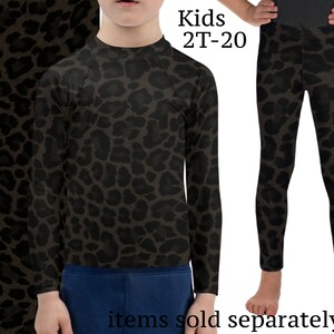 May include: A black and brown leopard print long-sleeve shirt and leggings for kids. The text "Kids 2T-20" is printed on the image. The text "items sold separately" is printed at the bottom of the image.