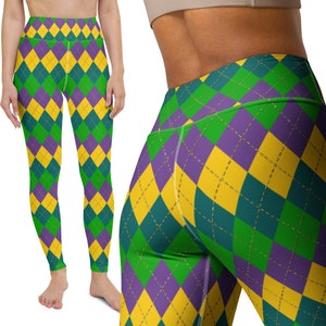 Pode incluir: Leggings de cintura alta com um padrão de losangos repetido em amarelo, verde e roxo. As leggings são justas e feitas de um material elástico. O design lembra um padrão de arlequim.