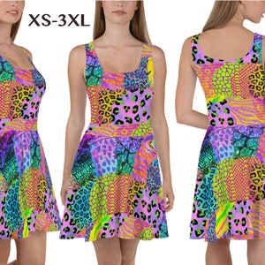 Op de afbeelding: Een kleurrijke, mouwloze jurk met een patchwork-ontwerp met verschillende dierenprints, waaronder luipaard, zebra en slang. De jurk heeft een aansluitend bovenlijf en een uitlopende rok. De jurk is verkrijgbaar in de maten XS-3XL.