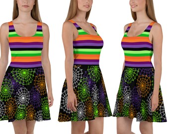 Puede incluir: Un vestido skater negro con un corpiño a rayas de colores y un patrón de telaraña en la falda. Las rayas son moradas, naranjas, verdes y negras.