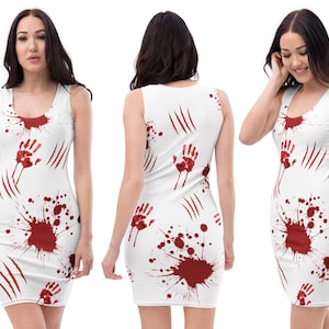 Pode incluir: Vestido branco sem mangas com um padrão de impressões de mãos vermelhas, respingos de sangue e marcas de garras. O vestido tem um decote redondo e um corte justo. O desenho repete-se na frente e nas costas.