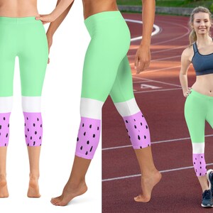 May include: Mint green leggings with white and light purple panels. The light purple panels feature a black dot pattern, resembling watermelon. The leggings are designed for athletic wear and are shown on a model.